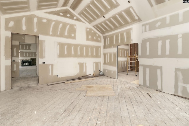 unfurnished room featuring light hardwood / wood-style flooring and lofted ceiling