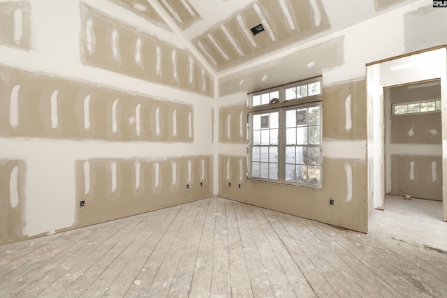 empty room featuring light hardwood / wood-style floors and vaulted ceiling