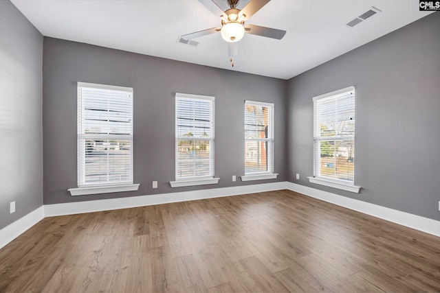 spare room with ceiling fan, plenty of natural light, and light hardwood / wood-style flooring