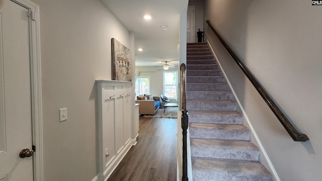 stairway with ceiling fan and hardwood / wood-style flooring