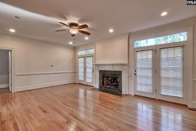 unfurnished living room with light hardwood / wood-style floors, ceiling fan, ornamental molding, and a premium fireplace