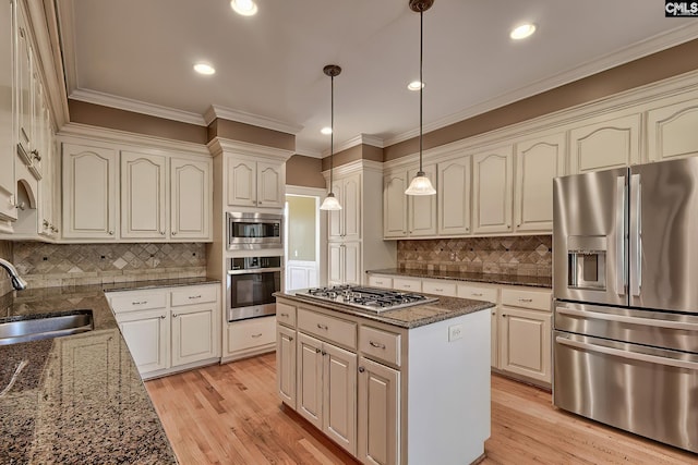 kitchen featuring sink, dark stone countertops, appliances with stainless steel finishes, tasteful backsplash, and decorative light fixtures