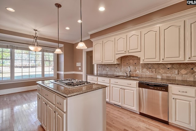 kitchen featuring pendant lighting, sink, appliances with stainless steel finishes, and dark stone counters