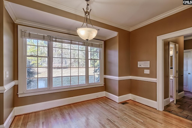 spare room featuring light wood-type flooring and crown molding