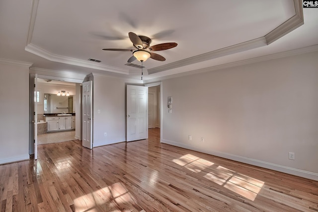 unfurnished bedroom featuring a raised ceiling, ceiling fan, and light wood-type flooring