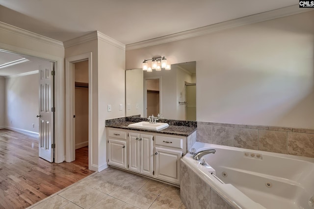 bathroom featuring tile patterned floors, tiled bath, vanity, and ornamental molding