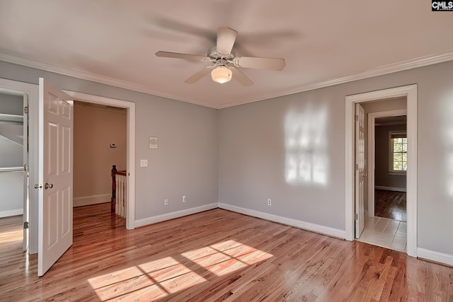 unfurnished bedroom with ceiling fan, crown molding, and light wood-type flooring