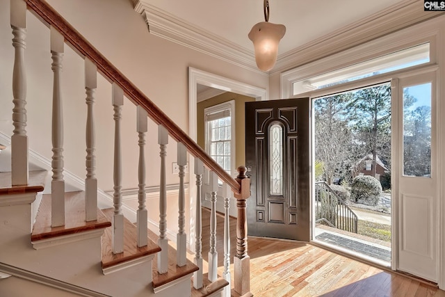 entryway featuring light wood-type flooring and ornamental molding