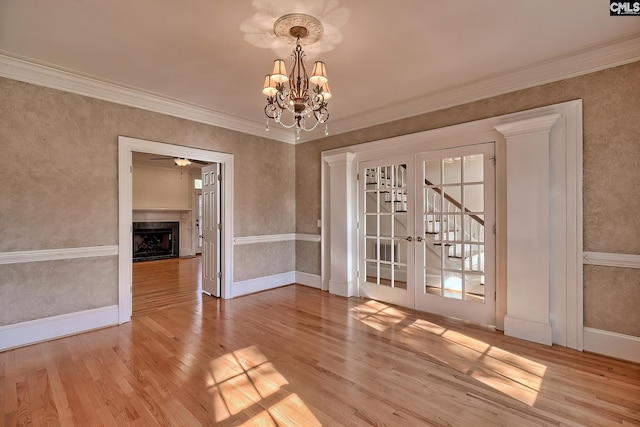 unfurnished dining area with light wood-type flooring, ornamental molding, and an inviting chandelier