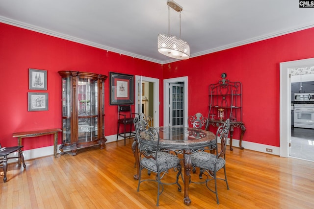 dining room with hardwood / wood-style floors and crown molding