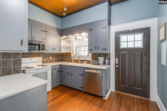 kitchen featuring backsplash, sink, dark hardwood / wood-style floors, gray cabinets, and appliances with stainless steel finishes