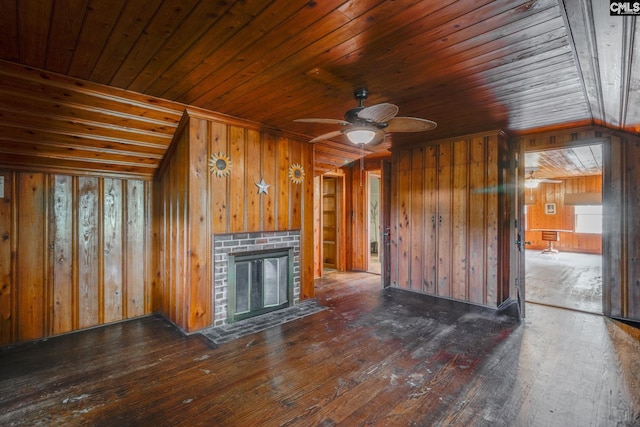 unfurnished living room featuring dark hardwood / wood-style flooring, wood ceiling, ceiling fan, wooden walls, and a fireplace