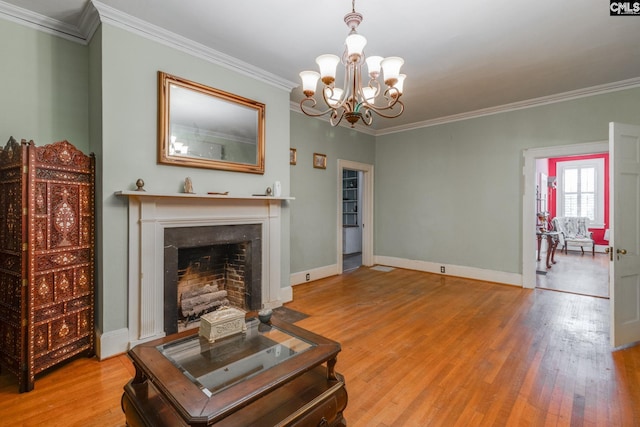 living room featuring a notable chandelier, light hardwood / wood-style floors, and ornamental molding