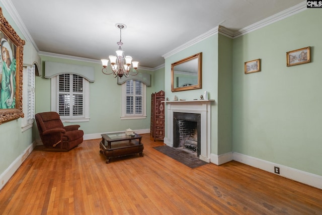 sitting room with wood-type flooring, crown molding, and an inviting chandelier