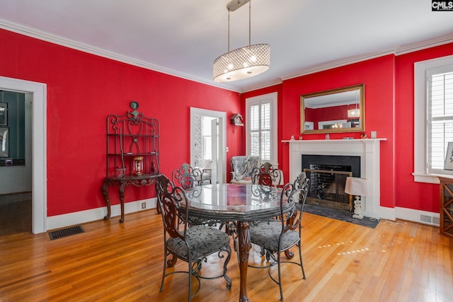 dining space featuring wood-type flooring and ornamental molding