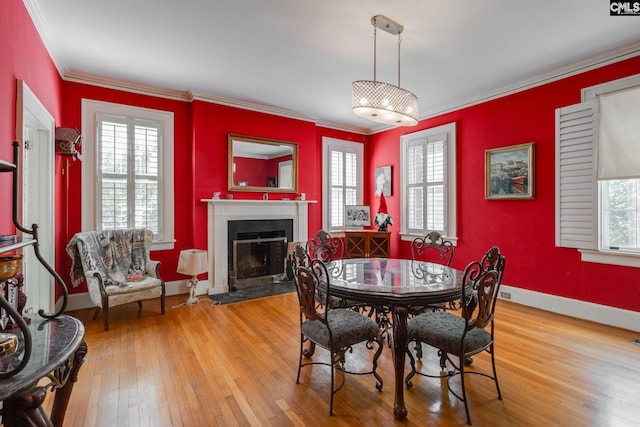 dining room with light hardwood / wood-style floors and crown molding