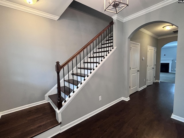 stairs featuring a chandelier, hardwood / wood-style flooring, and ornamental molding