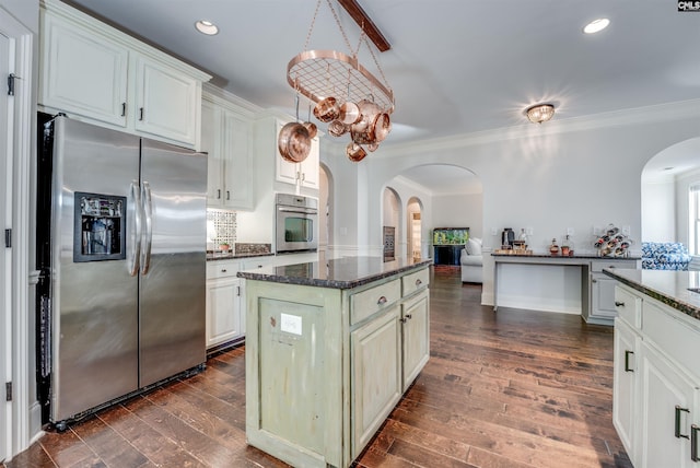 kitchen with a kitchen island, white cabinetry, stainless steel appliances, and ornamental molding