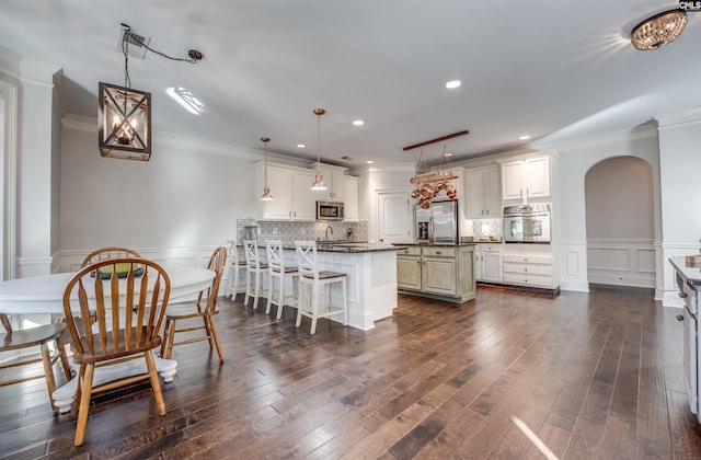 kitchen featuring a breakfast bar area, a center island, white cabinets, and stainless steel appliances