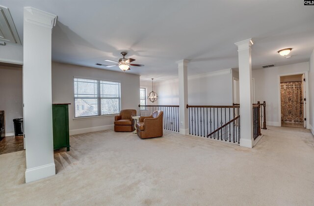 sitting room featuring ceiling fan with notable chandelier, light colored carpet, and crown molding