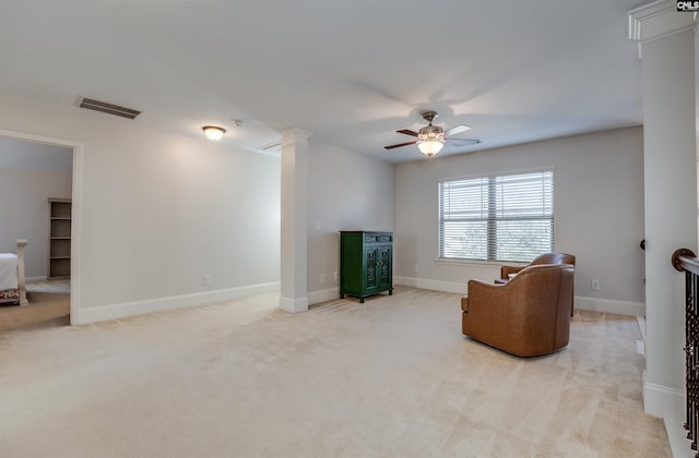 living area with light colored carpet and ceiling fan