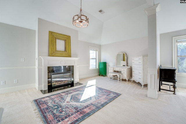 carpeted living room featuring a high end fireplace, lofted ceiling, and an inviting chandelier