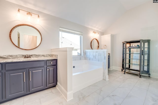 bathroom featuring vanity, vaulted ceiling, and a bathing tub