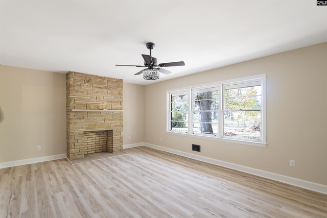 unfurnished living room featuring a fireplace, light hardwood / wood-style floors, and ceiling fan