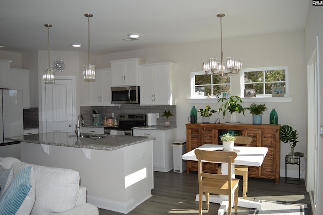 kitchen with light stone countertops, decorative backsplash, stainless steel appliances, sink, and white cabinets