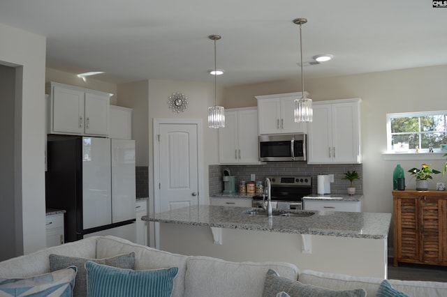 kitchen featuring pendant lighting, white cabinets, stainless steel appliances, and sink