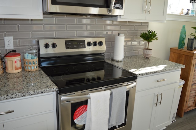 kitchen featuring decorative backsplash, stainless steel electric range oven, white cabinets, and light stone counters