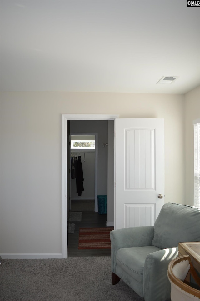 living area featuring dark colored carpet and plenty of natural light