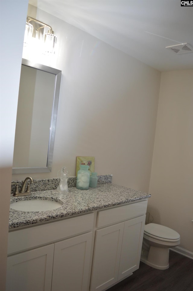 bathroom featuring hardwood / wood-style floors, vanity, and toilet