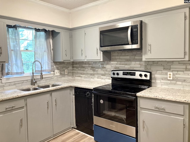 kitchen with sink, light hardwood / wood-style flooring, appliances with stainless steel finishes, and gray cabinetry