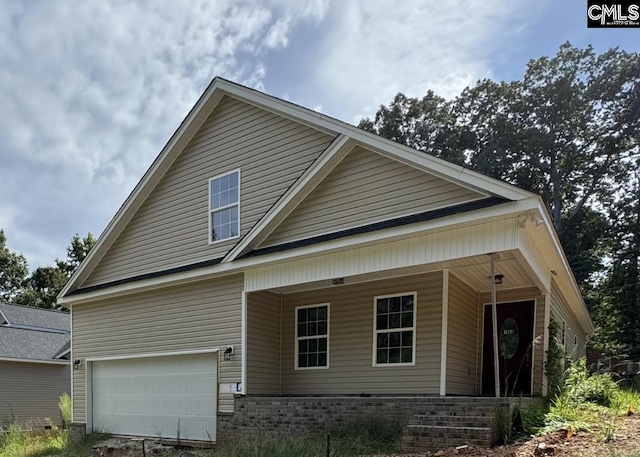 view of front of property featuring a porch and a garage