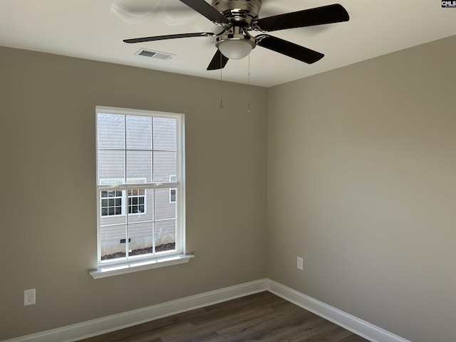 unfurnished room featuring a wealth of natural light, ceiling fan, and dark hardwood / wood-style floors