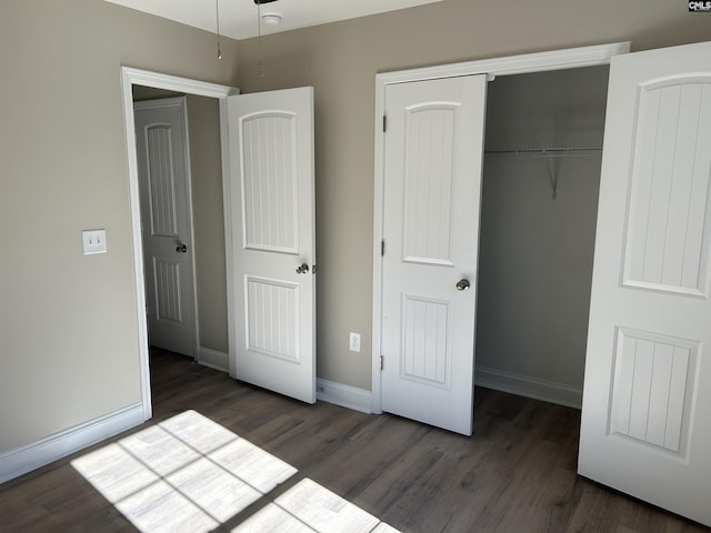 unfurnished bedroom with dark hardwood / wood-style floors and a closet