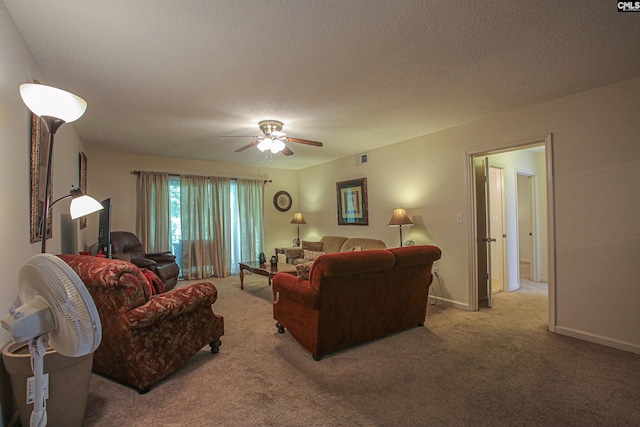 carpeted living room featuring ceiling fan and a textured ceiling