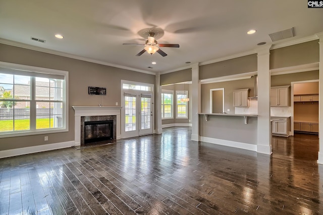 unfurnished living room with a fireplace, dark hardwood / wood-style floors, ceiling fan, and crown molding