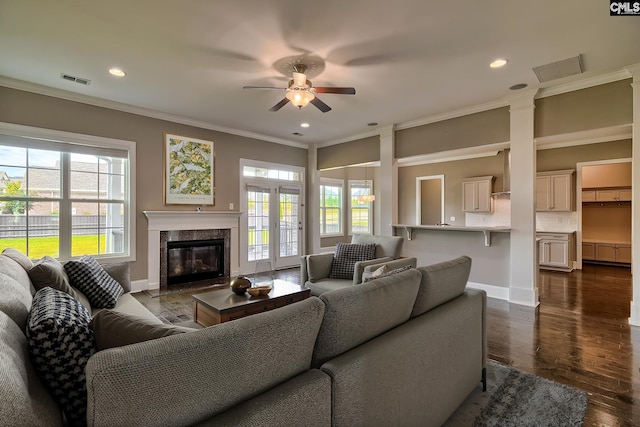 living room featuring a fireplace, ceiling fan, ornamental molding, and dark wood-type flooring