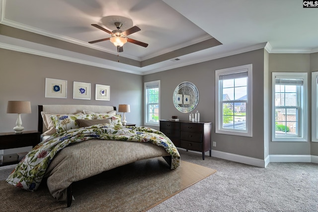 carpeted bedroom featuring a tray ceiling, ceiling fan, and crown molding