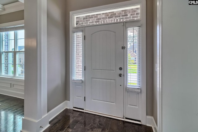 foyer entrance with dark hardwood / wood-style flooring, crown molding, and a healthy amount of sunlight