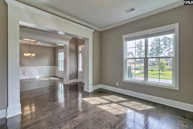 empty room with an inviting chandelier, dark hardwood / wood-style floors, and ornamental molding