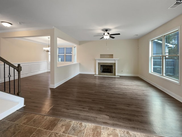 unfurnished living room with crown molding, dark hardwood / wood-style flooring, and ceiling fan with notable chandelier