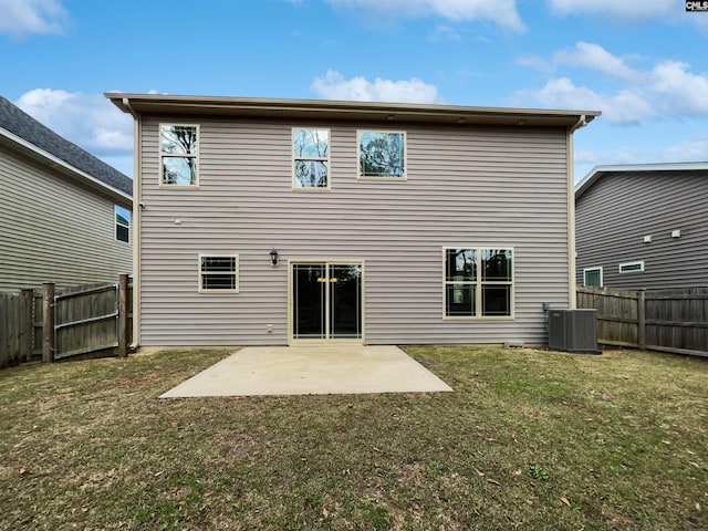 rear view of house with central AC, a patio area, and a lawn