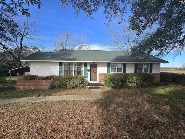 ranch-style home featuring a front lawn and a carport