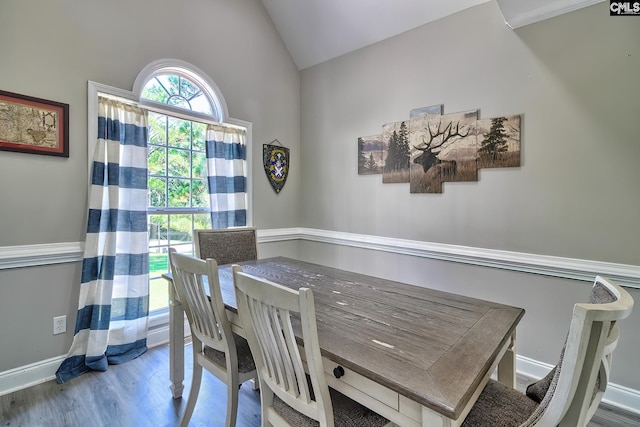 dining room featuring hardwood / wood-style flooring and vaulted ceiling