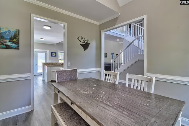 dining area with hardwood / wood-style flooring and crown molding