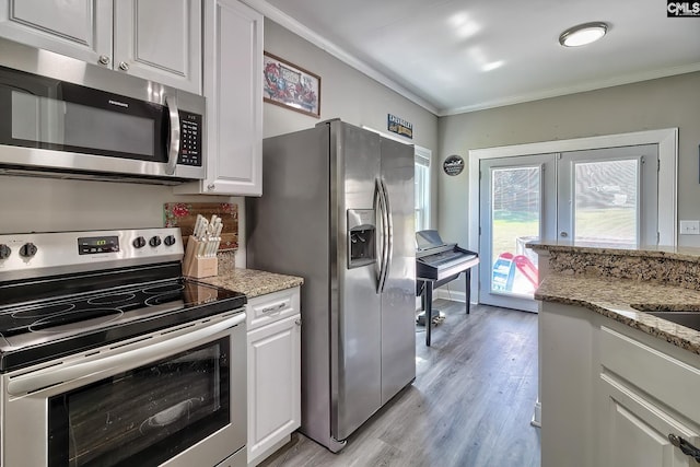 kitchen with white cabinetry, french doors, light stone counters, crown molding, and appliances with stainless steel finishes