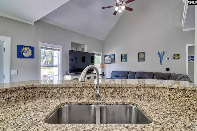 kitchen with light stone counters, sink, and ceiling fan